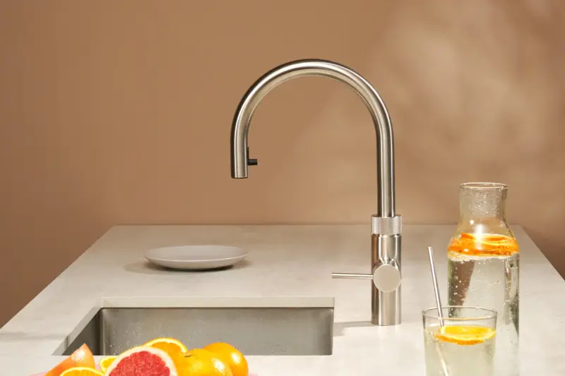 A stainless steel Quooker Flex tap on a kitchen island