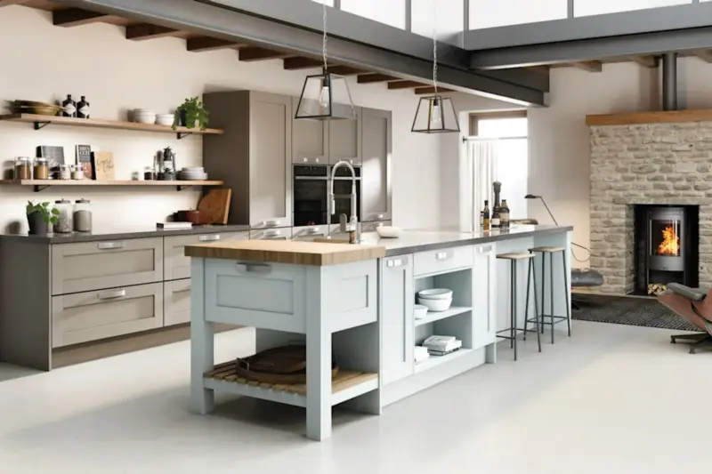A Caledonia kitchen with a pale blue island, open shelves and a wood-burning stove