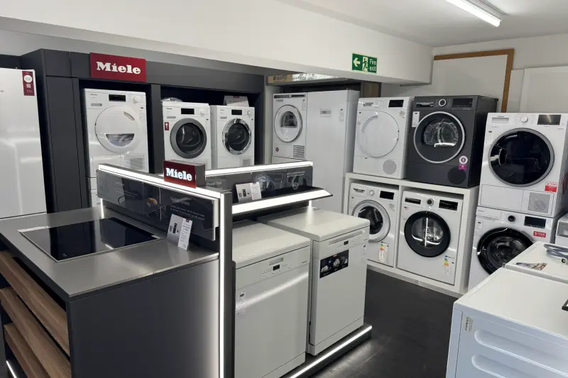 Washing machines, tumble dryers and dishwashers on display in our showroom, with Miele at the front