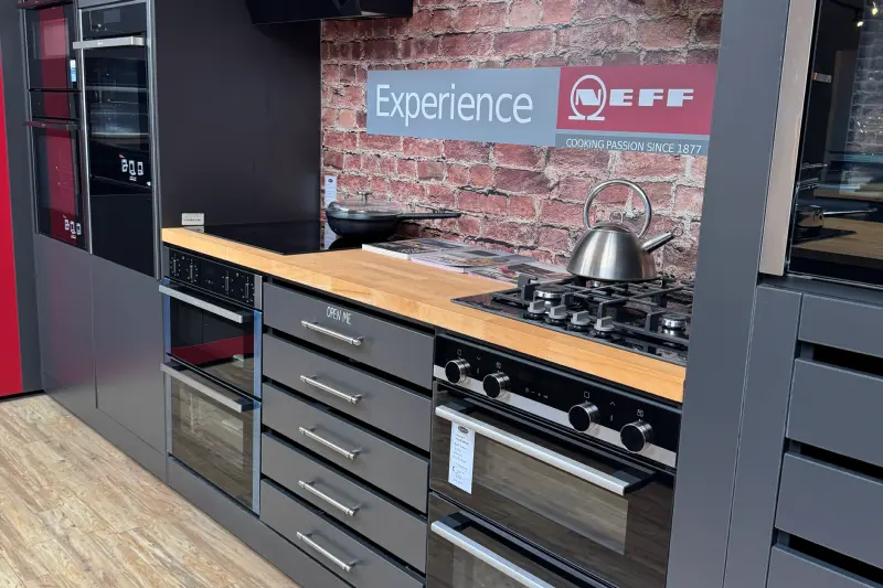 The NEFF display in our Hawkhurst showroom: built-in ovens, gas and induction hobs and a cooker hood, beneath an "Experience NEFF" sign